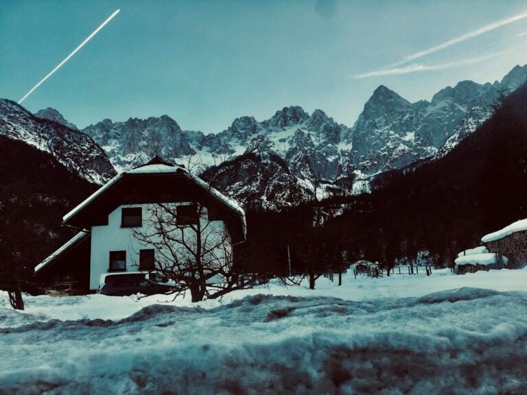 Snowy alpine house and mountains, illustrative winter scenery